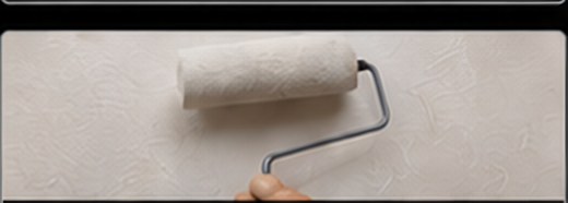 Paint roller on a freshly coated wall